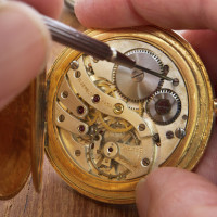 mechanism of a pocket watch timepiece being repaired